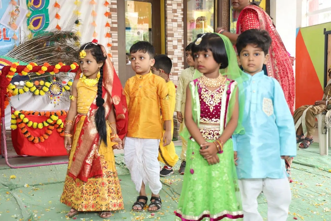 Small children dressed as Radha and Krishna at the Pride School cultural show, celebrating Indian traditions and culture.